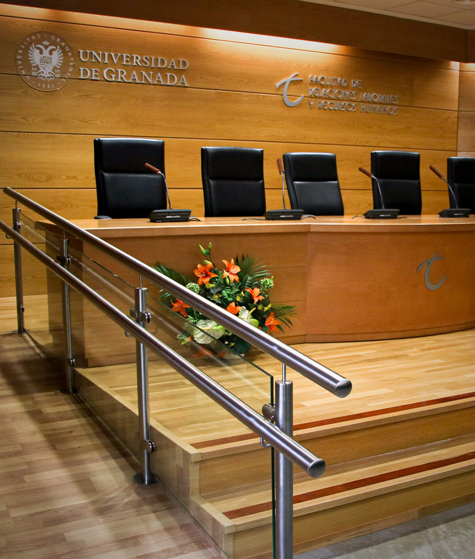 Salón de Actos de la Facultad de Relaciones Laborales y Recursos Humanos, con las paredes y la mesa central de madera