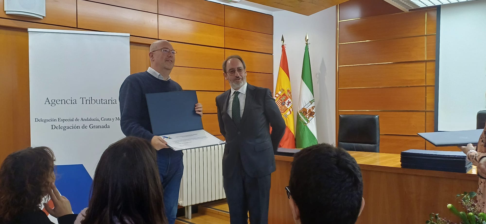 entrega diploma que recoge un profesor